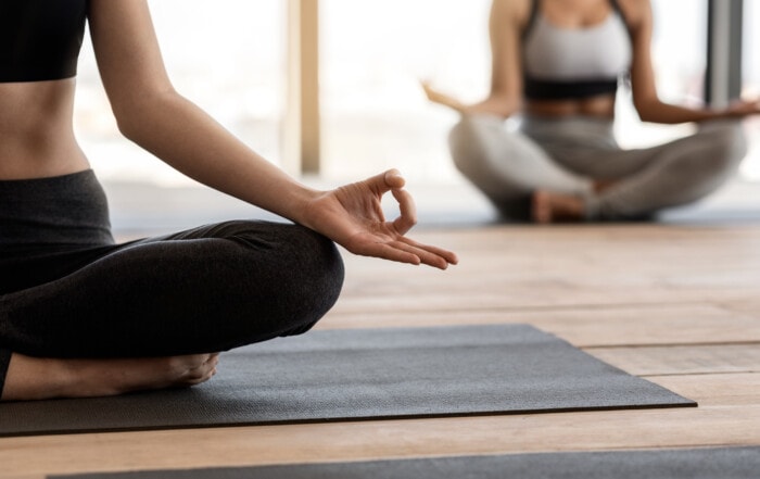 Zwei Frauen auf Yogamatten, die endlich mit Meditation anfangen