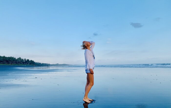 Kerstin Hardt übt bei Ebbe vor einem blauen Himmel präsent bleiben